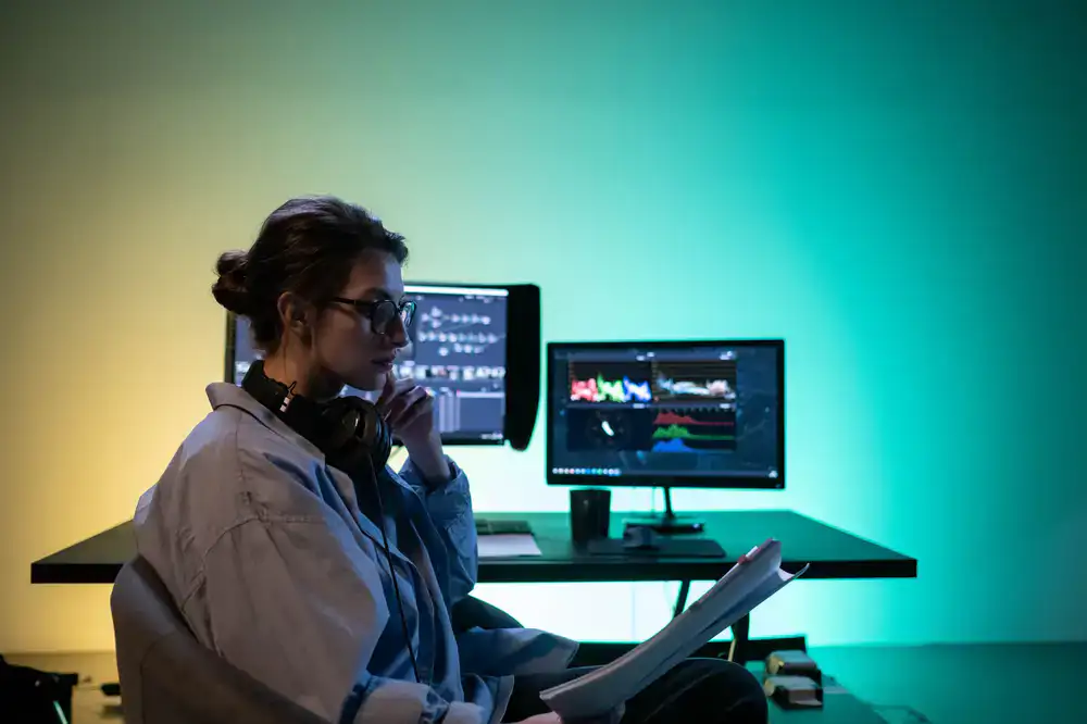 QA tester closely analyzing game collision metrics on a dual monitor setup